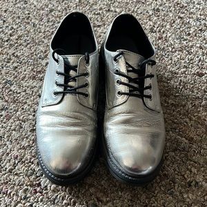 Fake Dr martens. Brand is seven dials. They’re silver and a little worn.